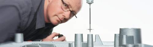 SAHM employee of the quality management looking at a part of a measuring machine