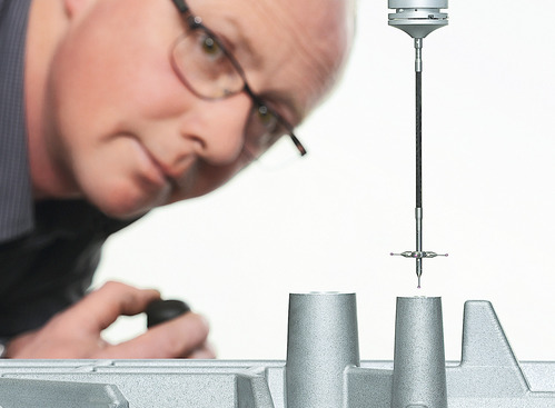 SAHM employee of the quality management looking at a part of a measuring machine